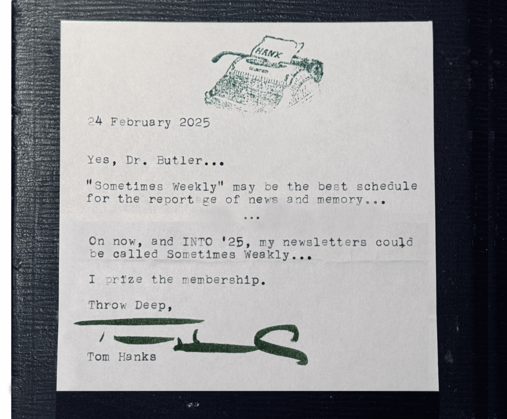 A type-written note from the American Actor Tom Hanks. On the top of the note is a green-ink stamp of a typewriter with a small piece of paper that reads "H. A N. X." The letter from Tom Hanks reads: "24 February 2025. Yes, Dr. Butler... 'Sometimes Weekly' may be the best schedule for the reportage of news and memory... On now, and INTO '25, my newsletters could be called Sometimes Weekly... I prize the membership. Throw Deep, Tom Hanks." Above Tom Hanks' type-written name is his signature in a thick green sharpie. 
